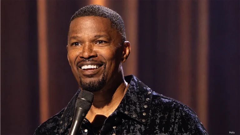 A close-up of Jamie Foxx performing on stage with a microphone in his new Hulu comedy special