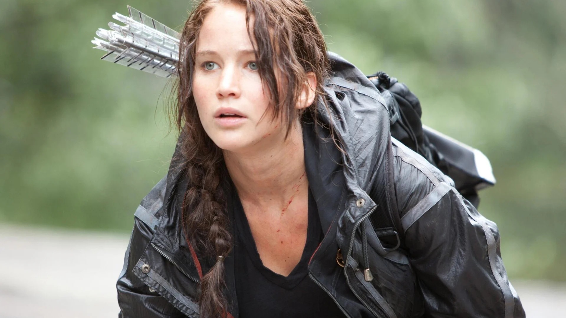 Jennifer Lawrence as Katniss Everdeen in the arena in The Hunger Games (2012) — black arena jacket, side braid, quiver of arrows over her shoulder