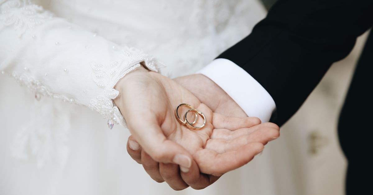 A couple holding hands showing wedding bands