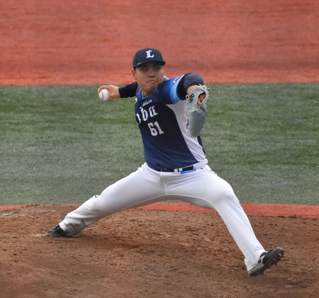 Kaima Taira pitching for the Saitama Seibu Lions, mid-delivery on the mound in his No. 61 Seibu jersey at Kamagaya Stadium
