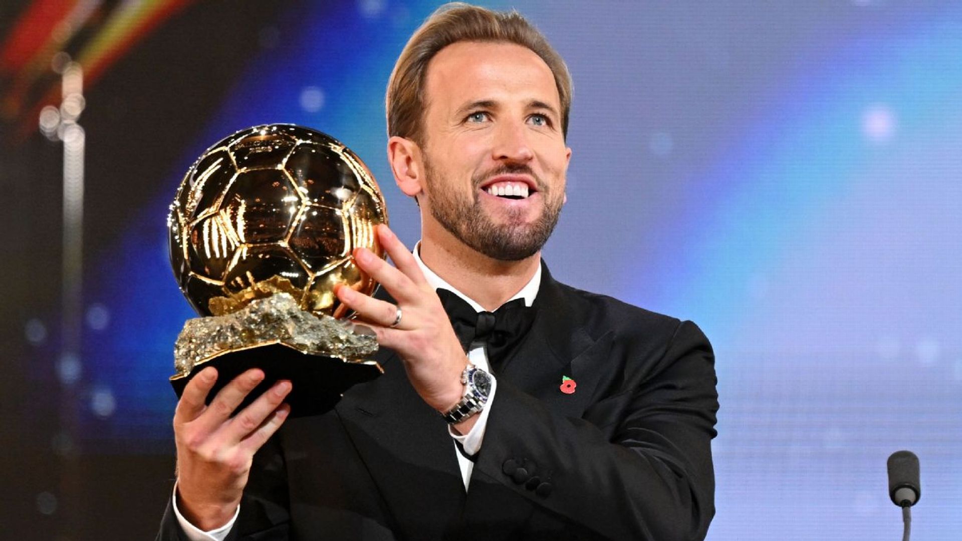 Harry Kane in black tie holding the golden Ballon d'Or trophy on stage at the London Palladium ceremony