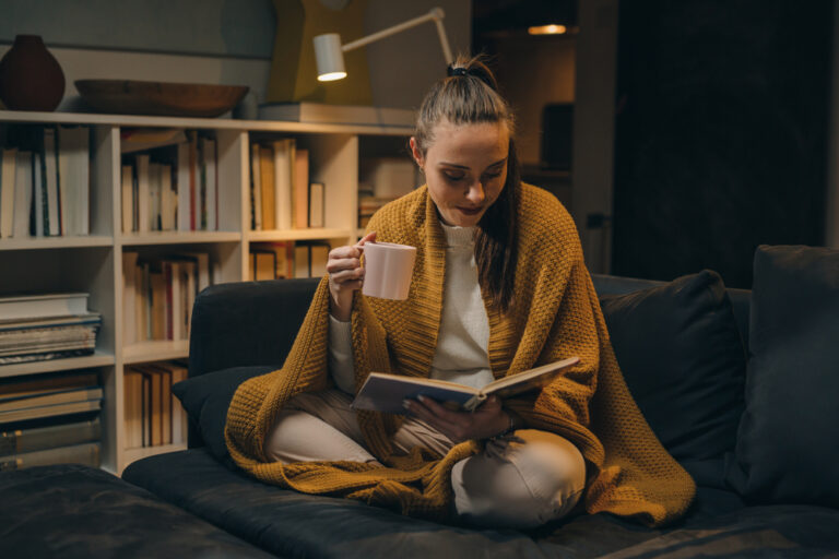 A cozy, warmly lit living room with a person relaxing