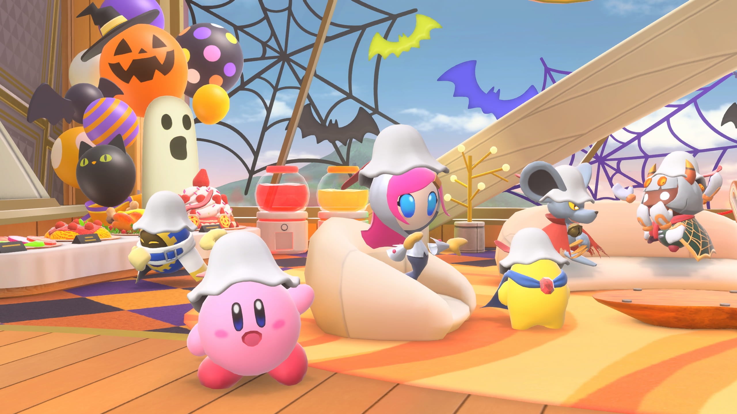 Official Kirby Air Riders Trick or Treat event art — Kirby in ghost headwear in a Halloween-decorated room with pumpkin balloons and spiderwebs