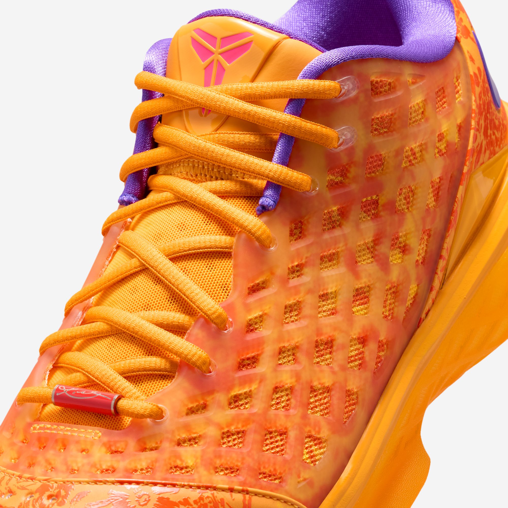 Macro detail of the “Mamba Eterno” — the translucent TPU cage over the floral underlayer, the Picante Red Kobe sheath logo on the tongue and the red lace lock carrying Kobe Bryant’s signature