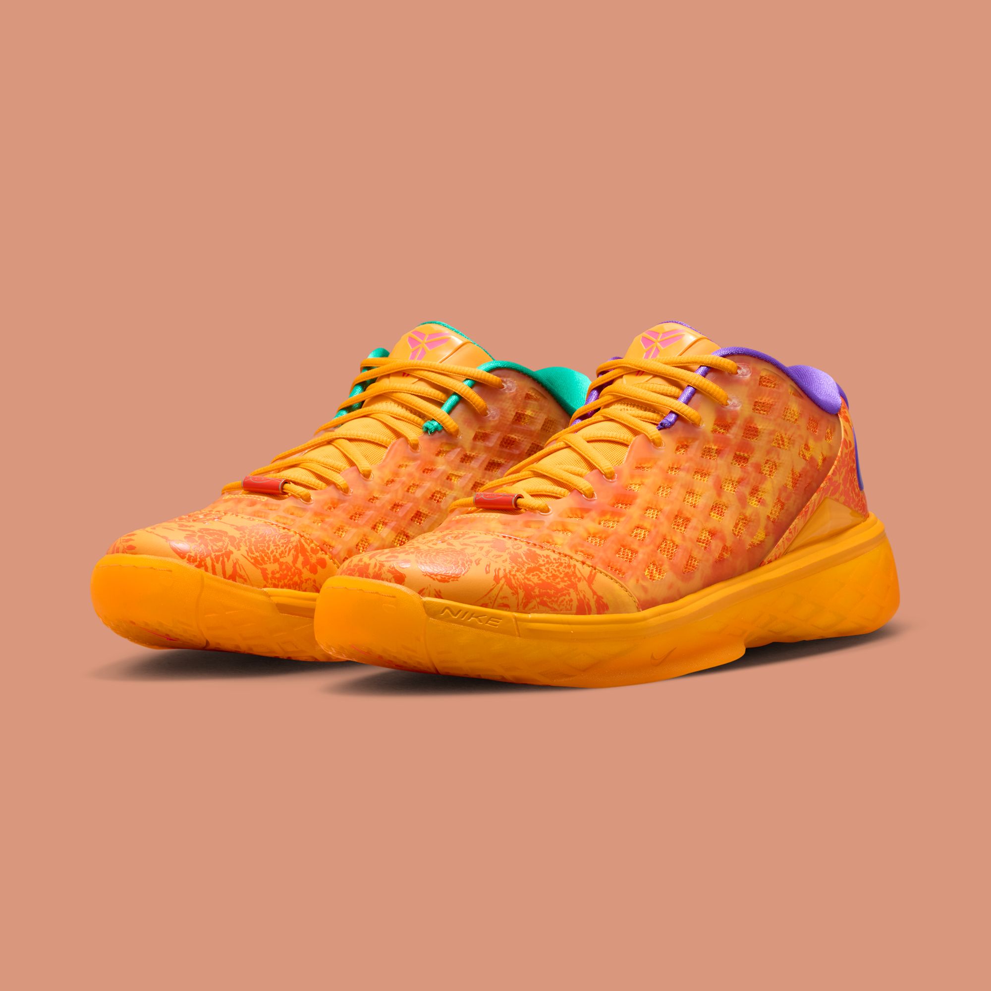 The “Mamba Eterno” pair in three-quarter view on the Sundial-peach studio background, the mismatched ankle collars showing