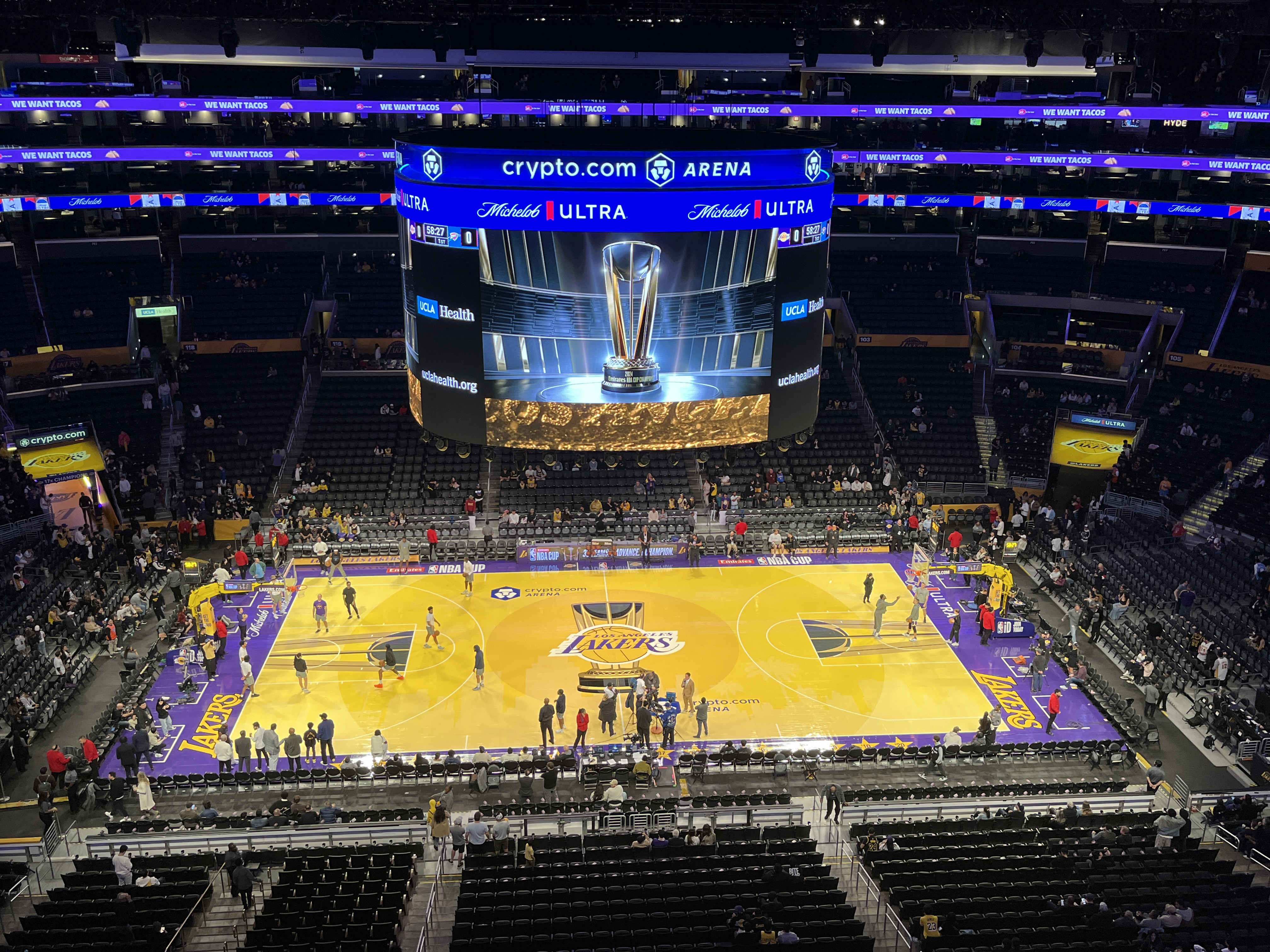 The Lakers' NBA Cup court inside Crypto.com Arena — the Los Angeles Lakers logo at center court, the NBA Cup trophy on the arena scoreboard