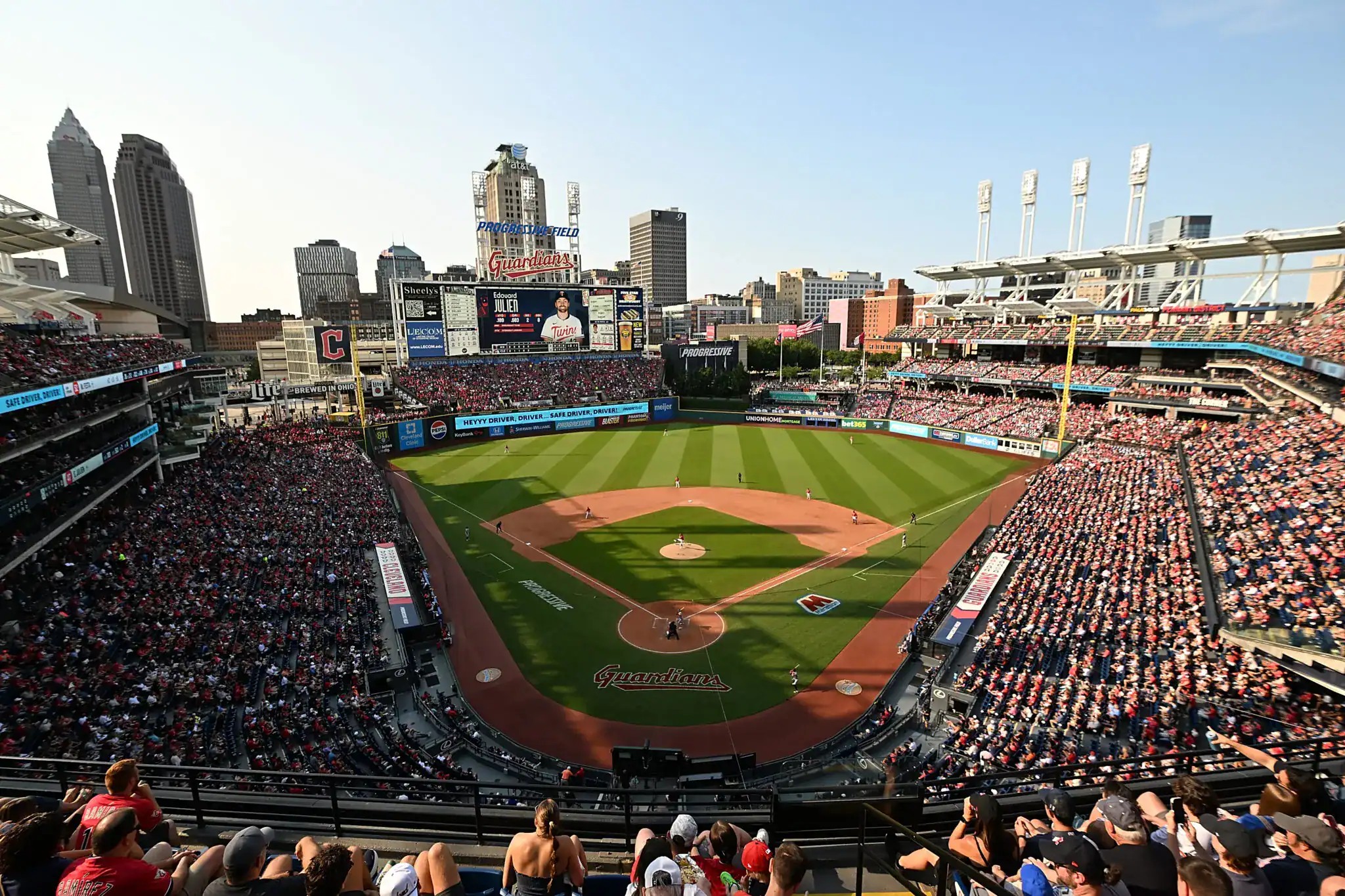 A bright daytime panoramic of Progressive Field in Cleveland — a packed house under a blue sky, where the Guardians shut out the White Sox 2-0 in ALDS Game 5 to advance to the ALCS