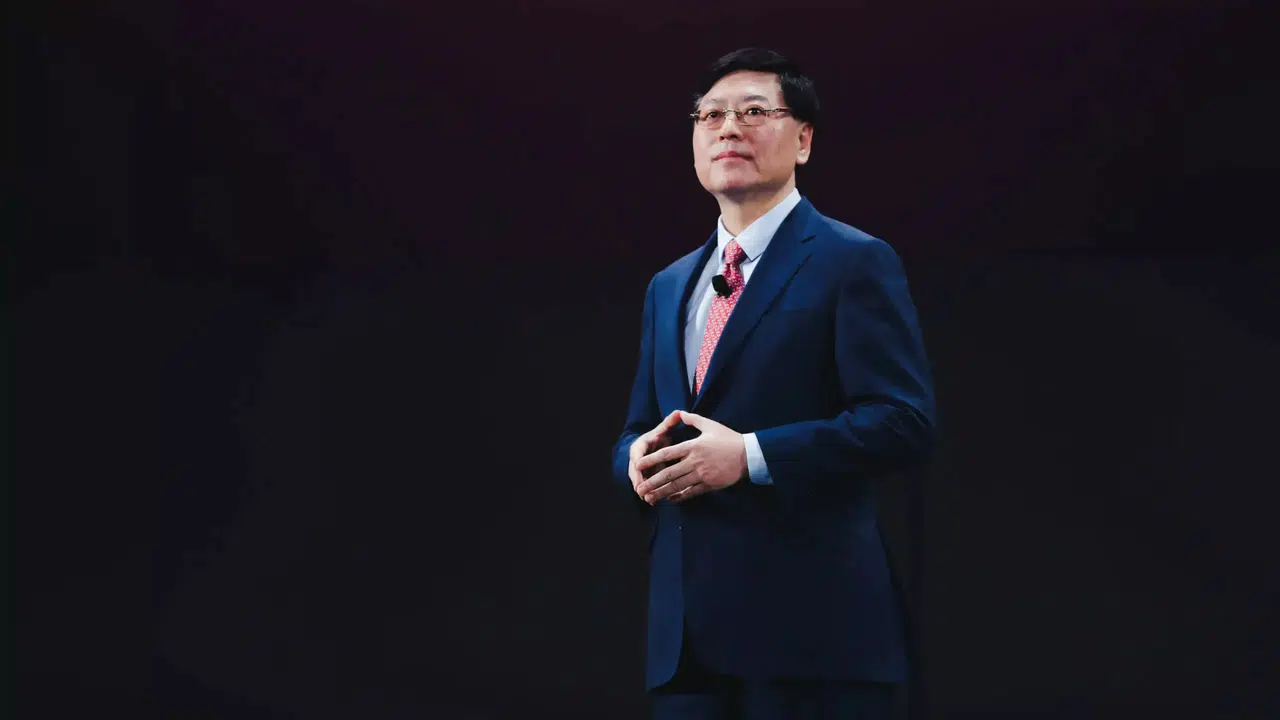 Yuanqing Yang on stage at a Lenovo event, dressed in a dark suit