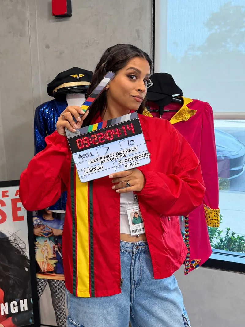 Lilly Singh holding a production slate on the set of her comeback sketch