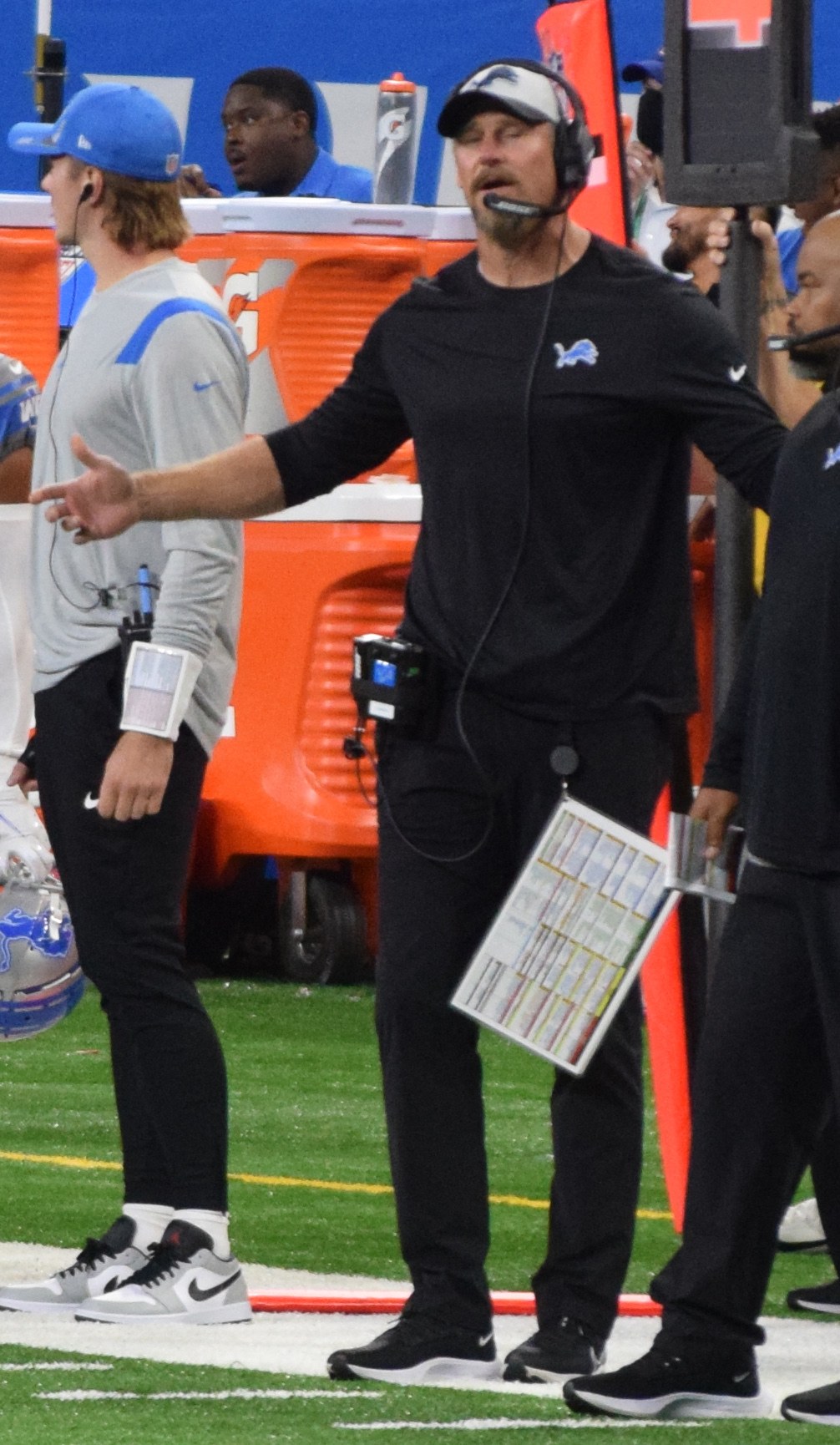 Detroit Lions head coach Dan Campbell on the sideline wearing a headset