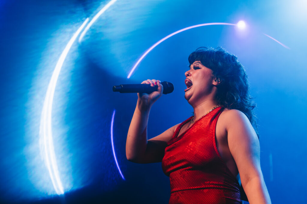 Lola Young performing live in a red dress