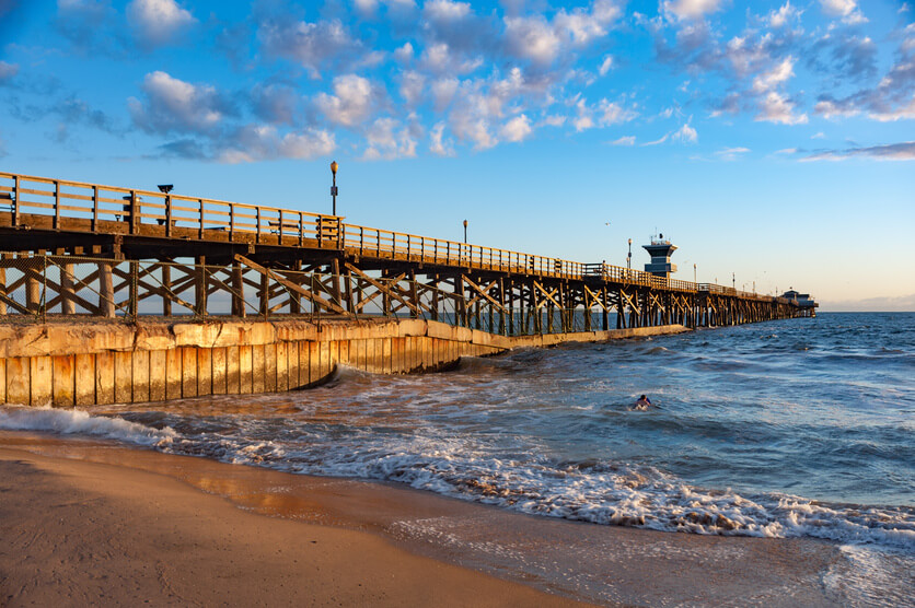 The Seal Beach pier with surf rolling in
