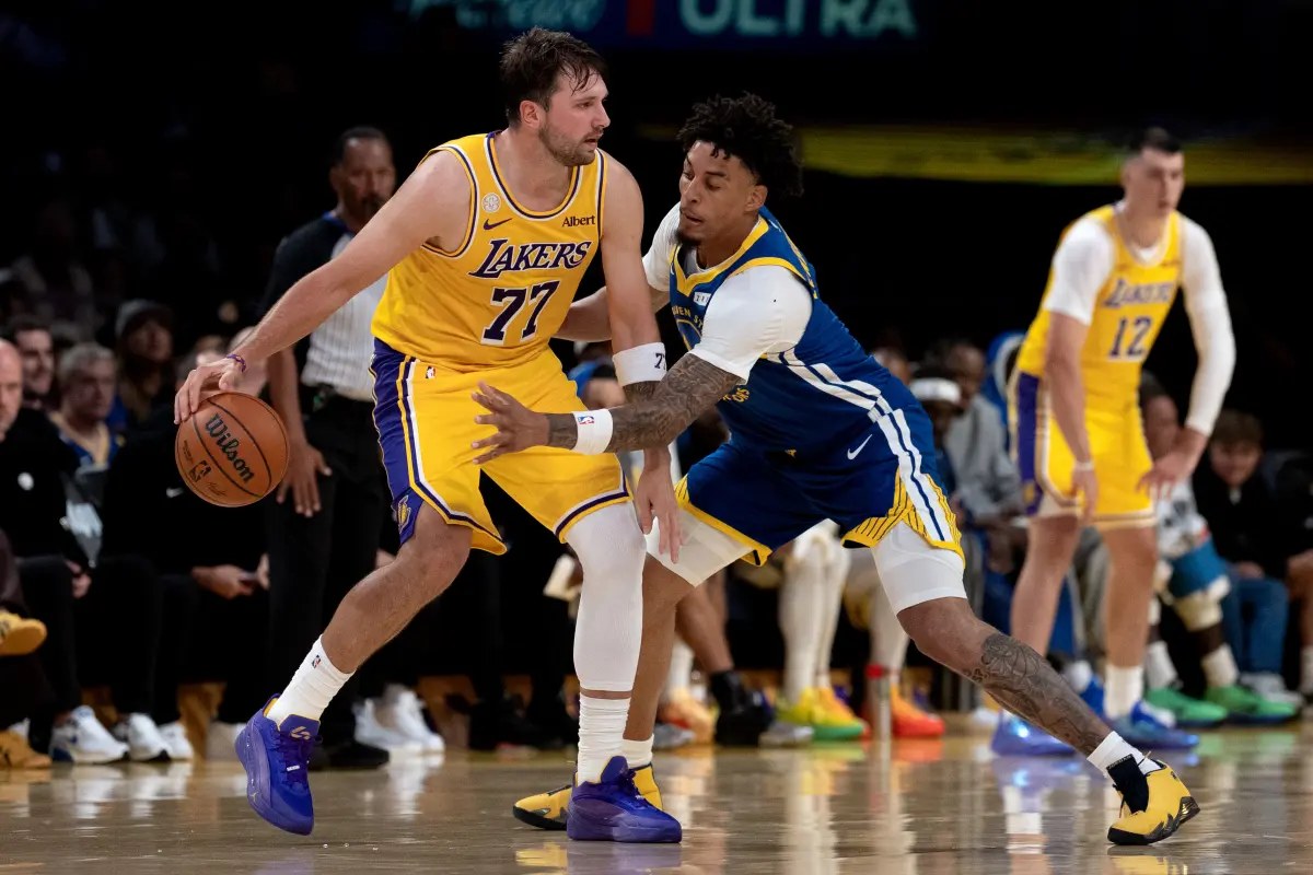 Luka Doncic of the Los Angeles Lakers drives against a Golden State Warriors defender during the Lakers 127-105 season-opening win on Oct. 21, 2026
