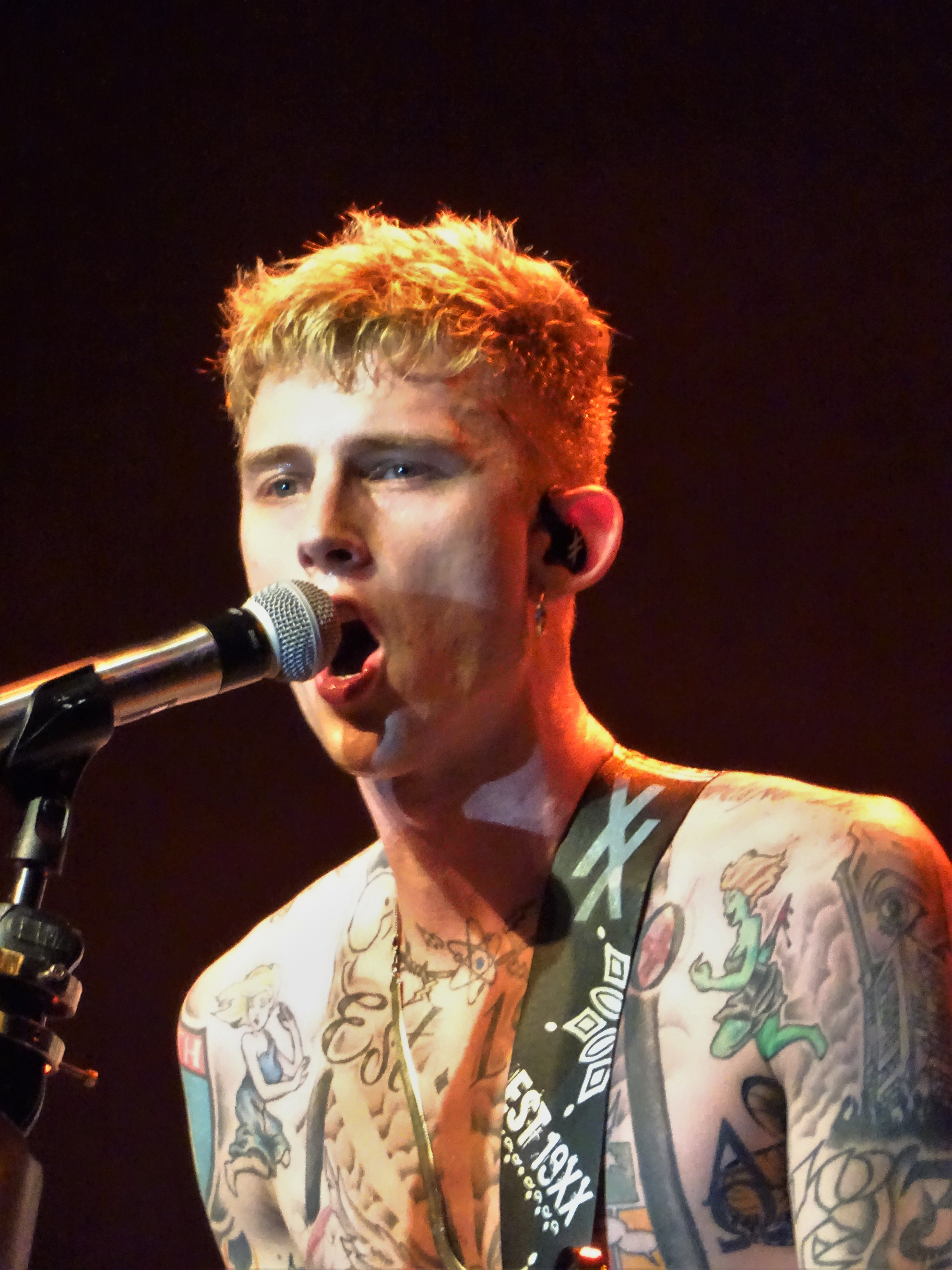 Machine Gun Kelly performing live, close up with a microphone