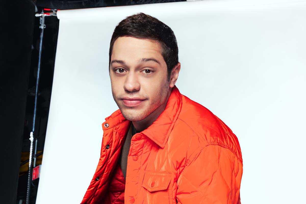 Pete Davidson in a studio portrait wearing a red jacket