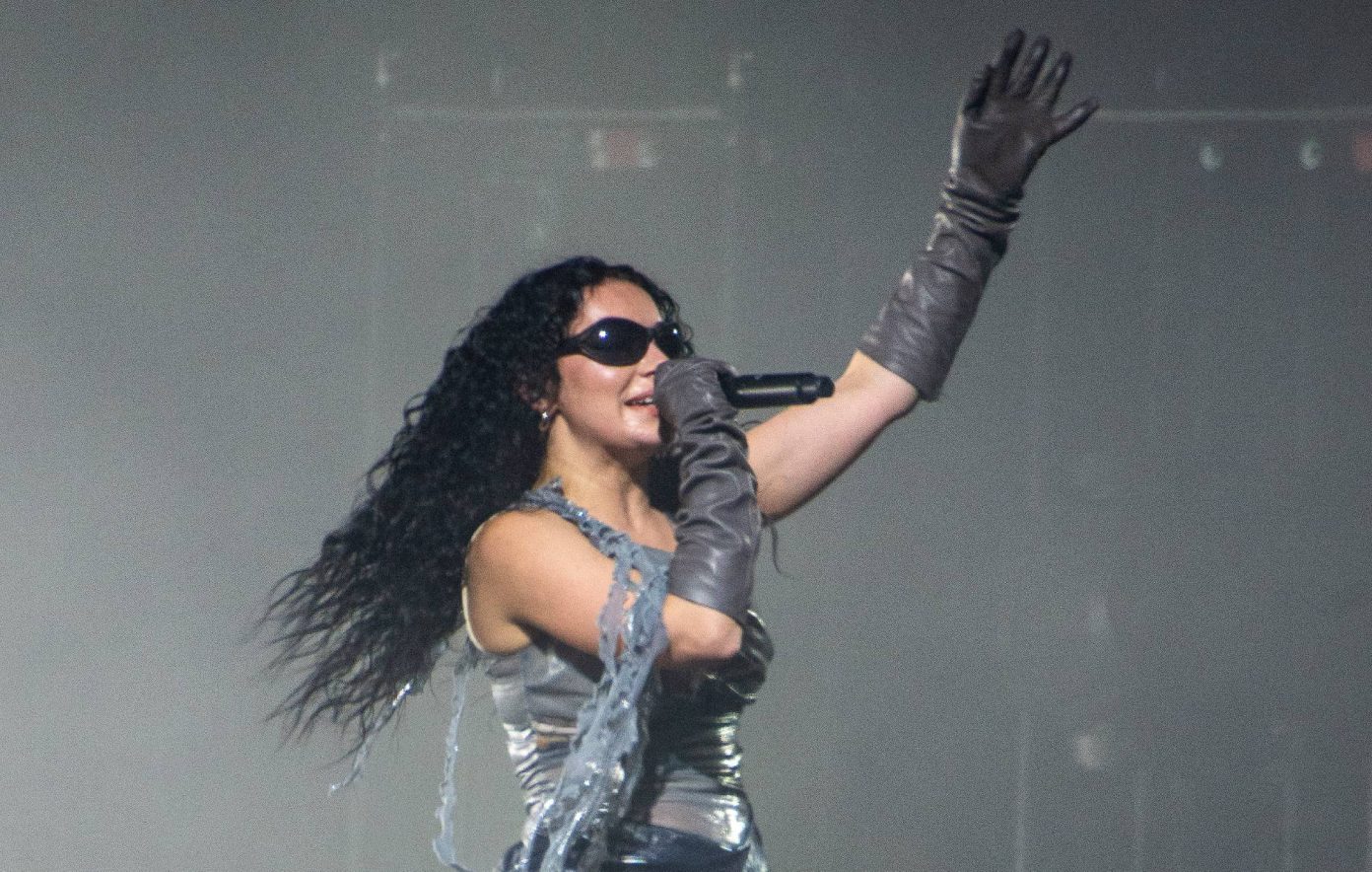 Charli xcx performing on stage under dramatic stage lights