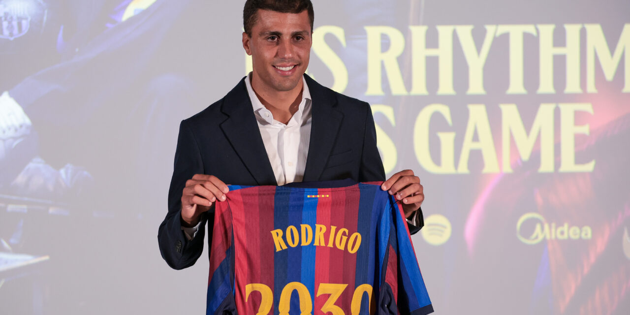Rodri holds up a Barcelona shirt at his unveiling after completing a ~£65.4m move from Manchester City