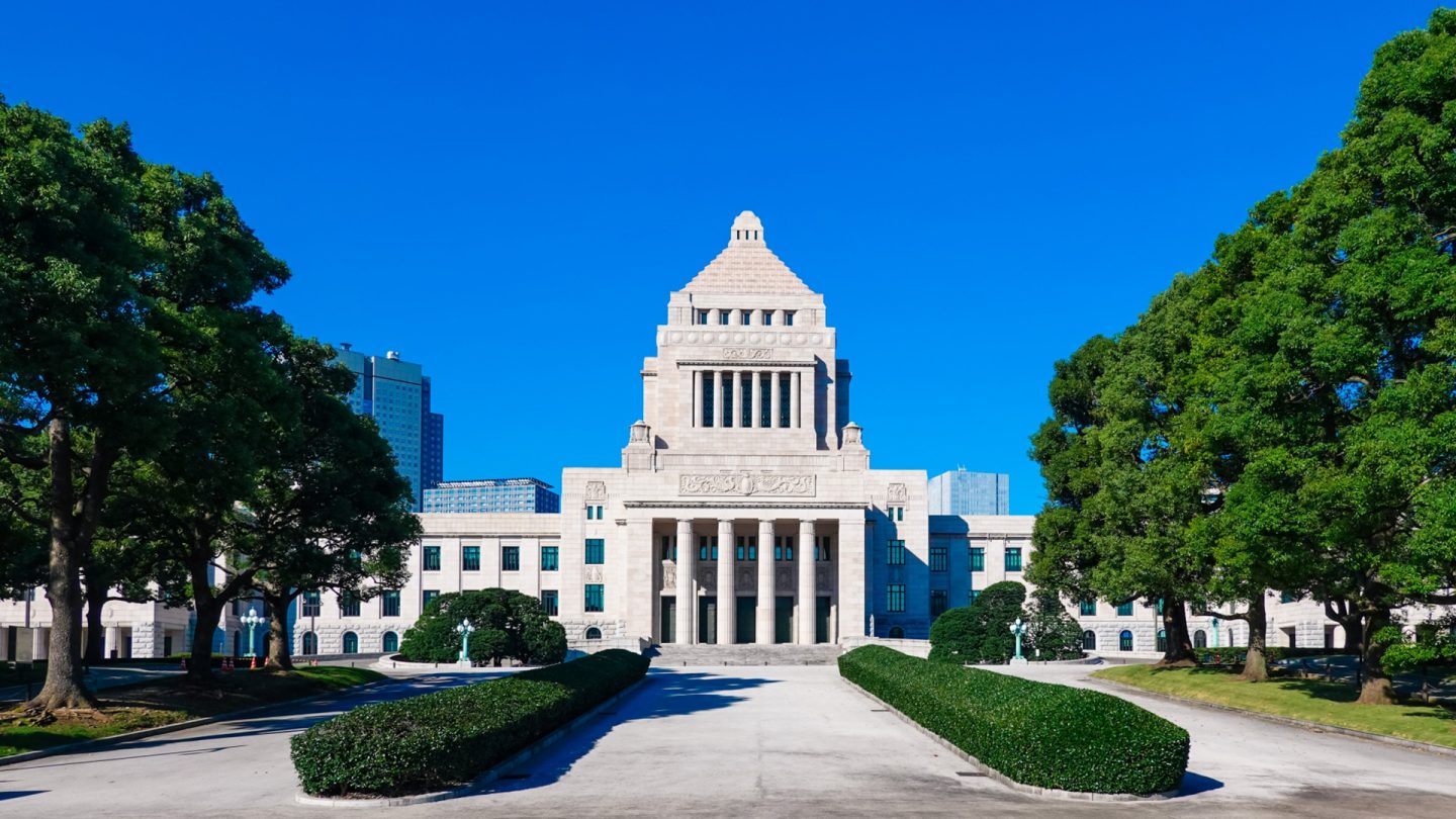 The National Diet building in Tokyo under a clear blue sky.