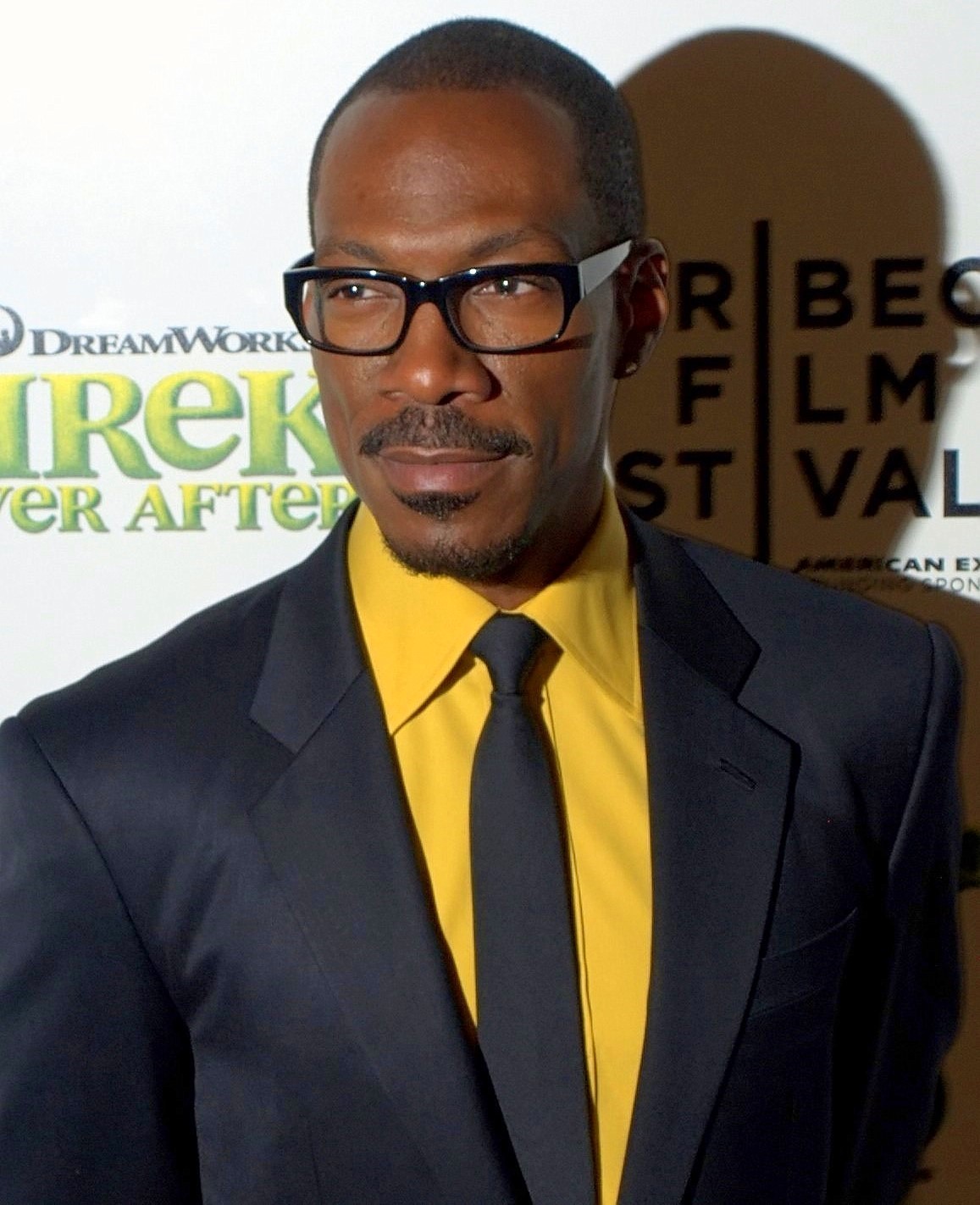 Eddie Murphy in glasses, a suit and yellow shirt at the 2010 Tribeca Film Festival premiere of 'Shrek Forever After.'