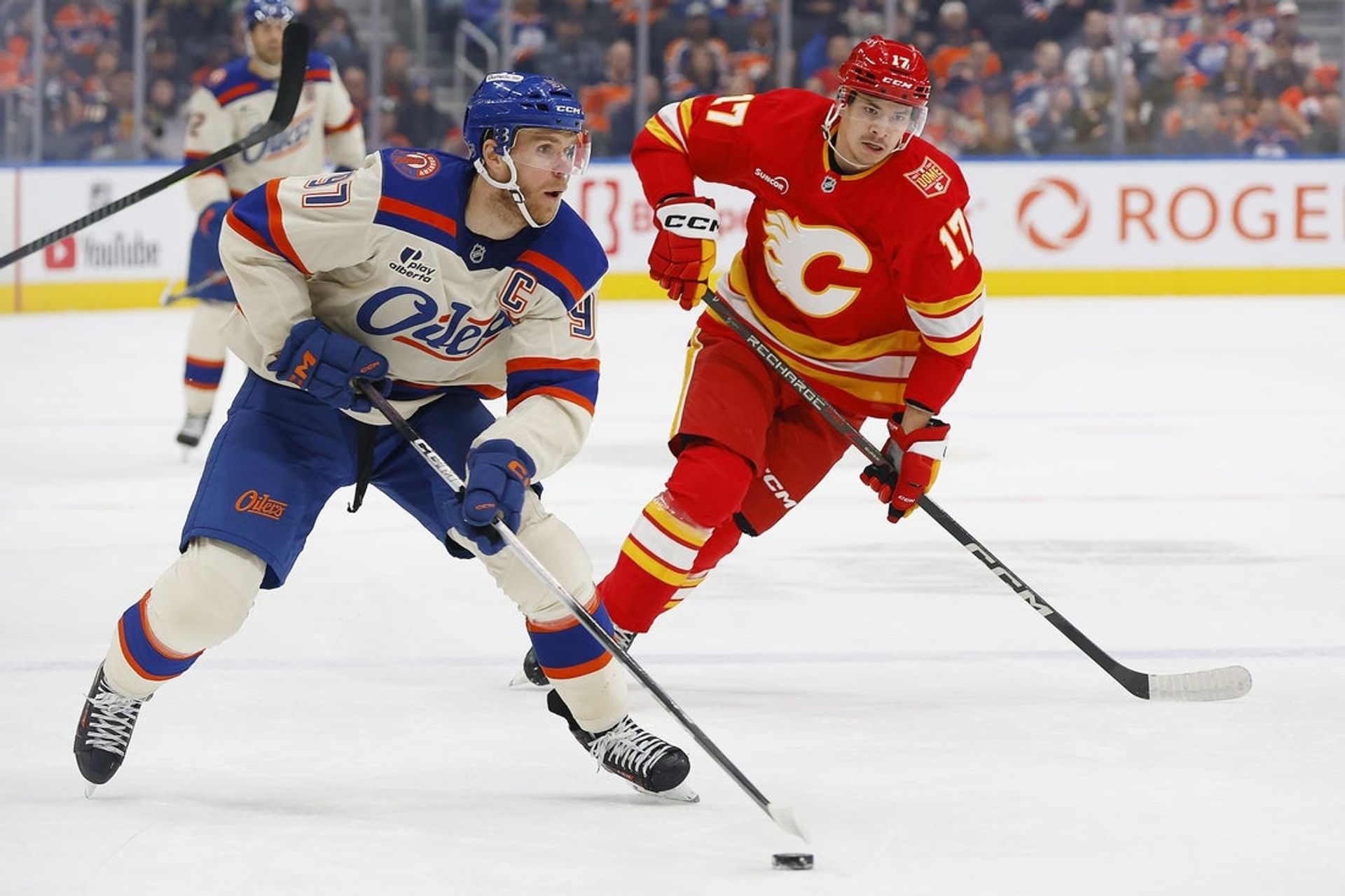 Connor McDavid (97) on the puck against Calgary's Yegor Sharangovich (17) in the first period at Rogers Place