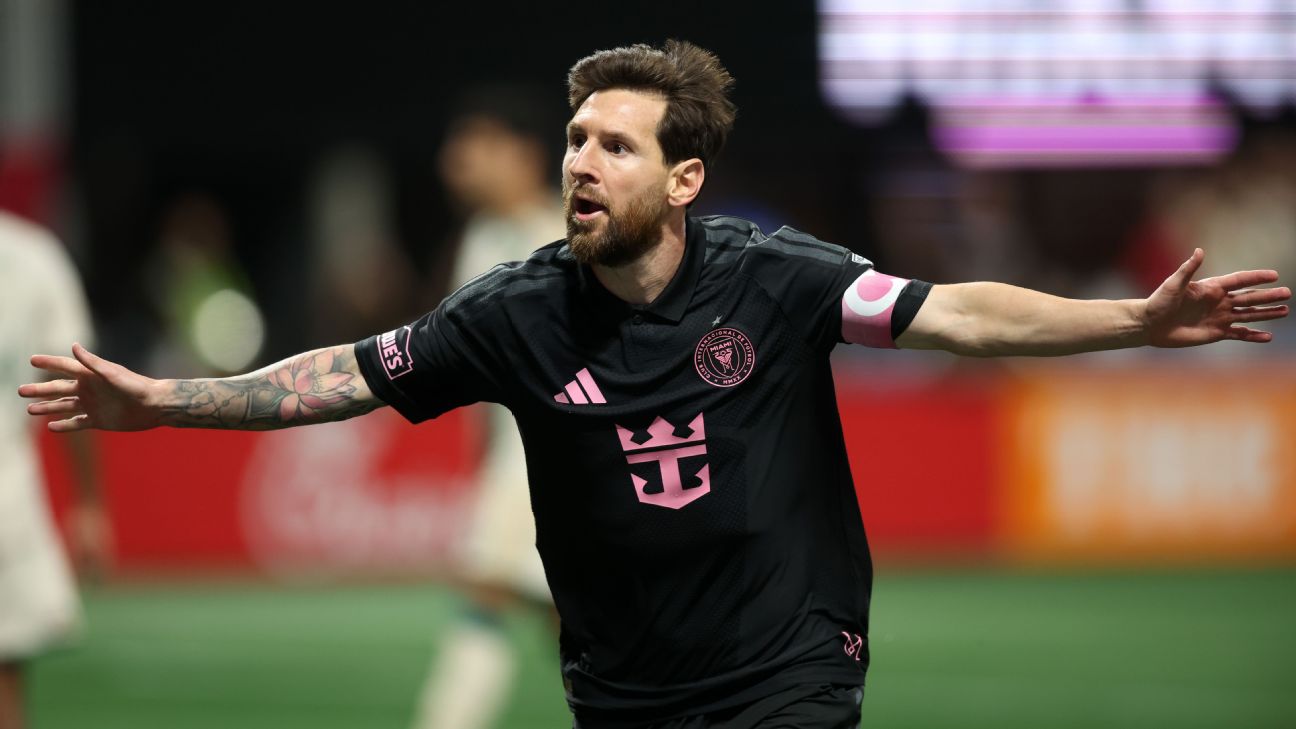 Lionel Messi in Inter Miami's black away kit, captain's armband on, celebrating with arms spread after scoring at Atlanta United