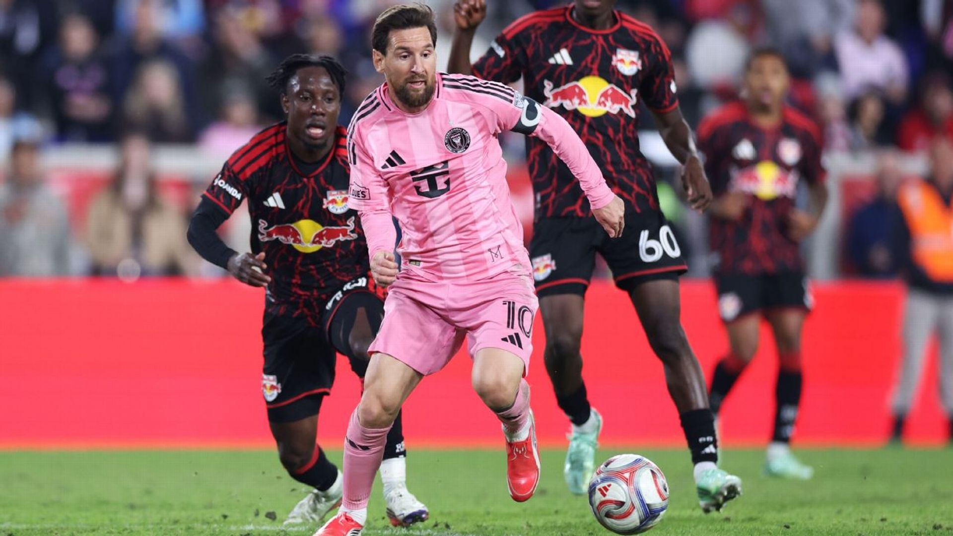 Lionel Messi, wearing Inter Miami's pink home kit with the No. 10 and the captain's armband, drives forward on the ball against Red Bull New York.