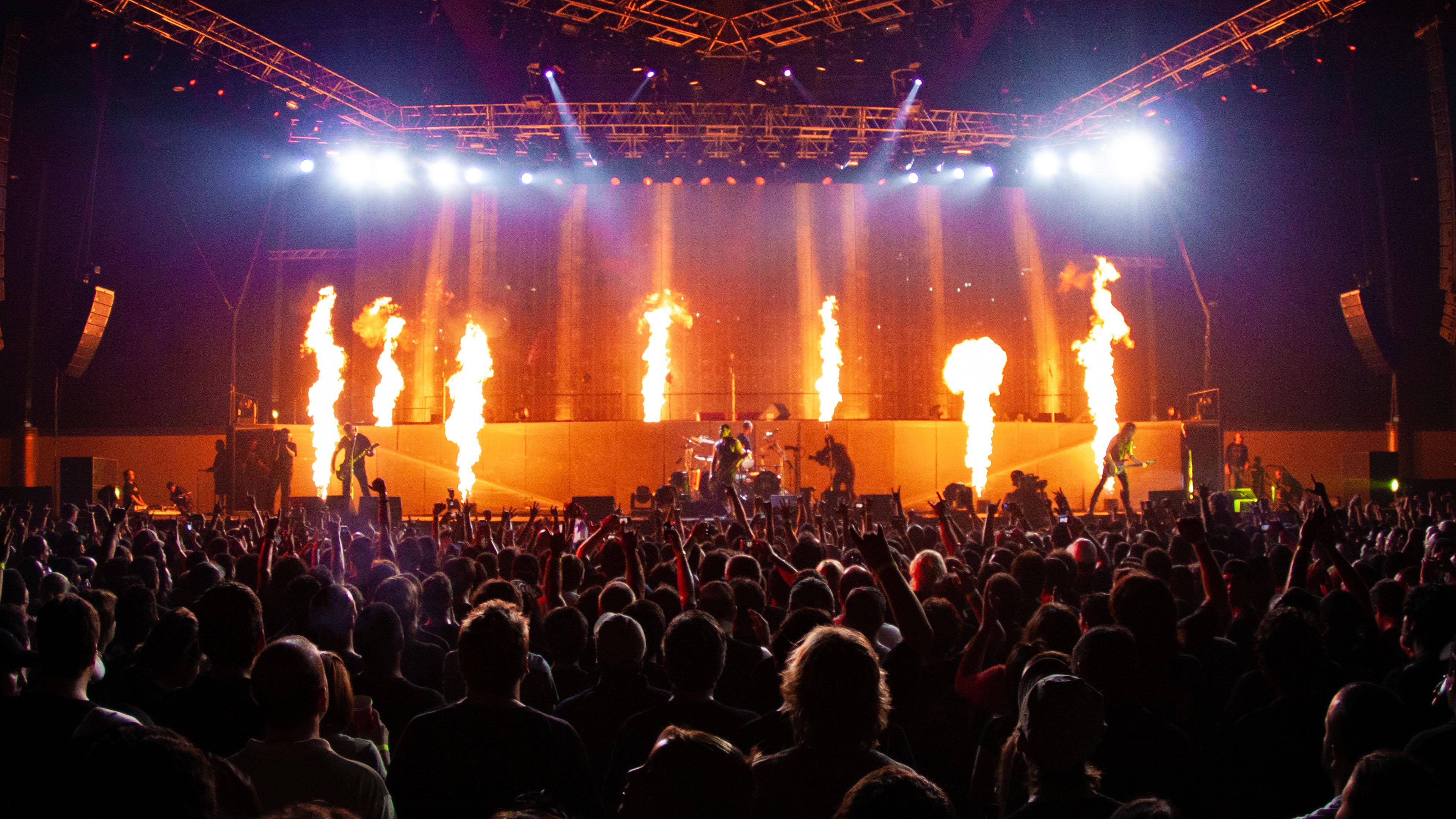 Metallica concert with dramatic stage lights and a huge crowd