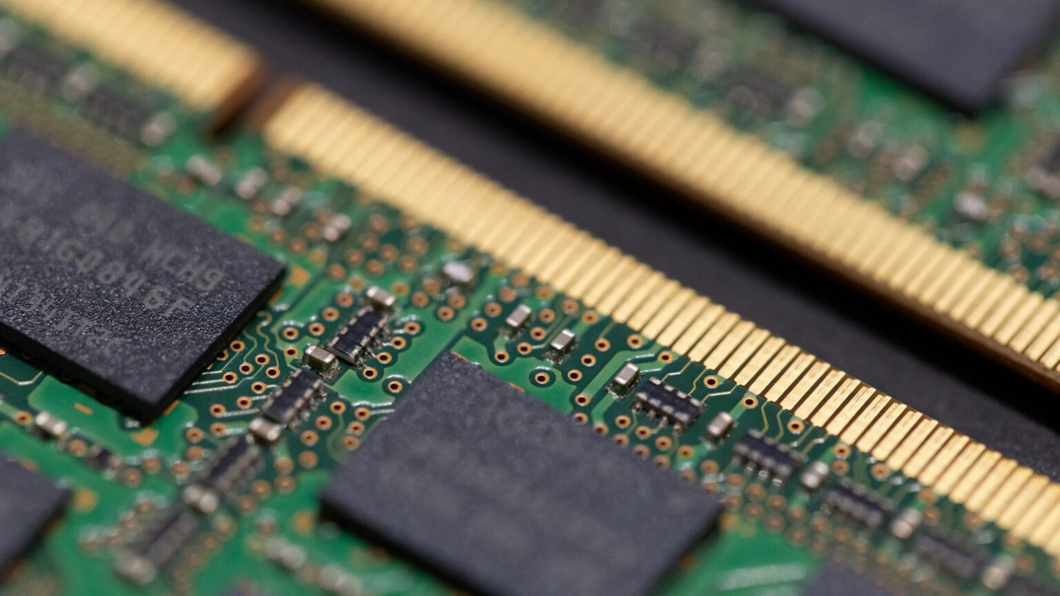 Close-up of RAM memory sticks showing the green circuit boards, gold contact pins, and memory chips