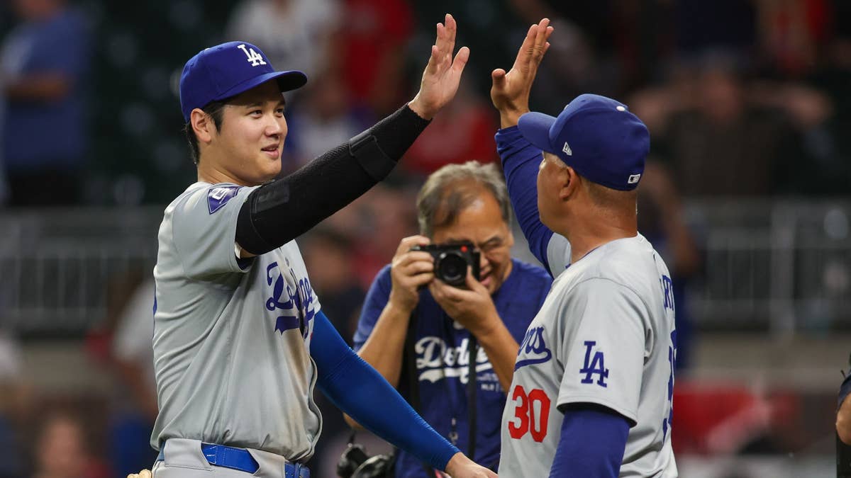 Shohei Ohtani high-fives Dodgers manager Dave Roberts while celebrating a win in Atlanta