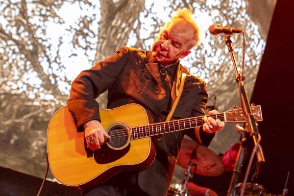 John Prine performing live with his guitar