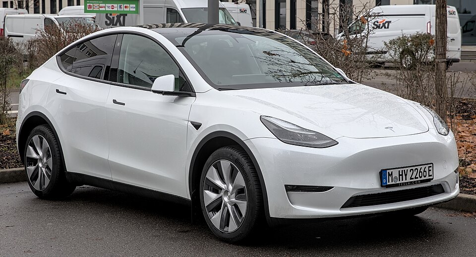 A white Tesla Model Y parked in daylight