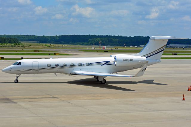 A Gulfstream business jet on a sunlit tarmac