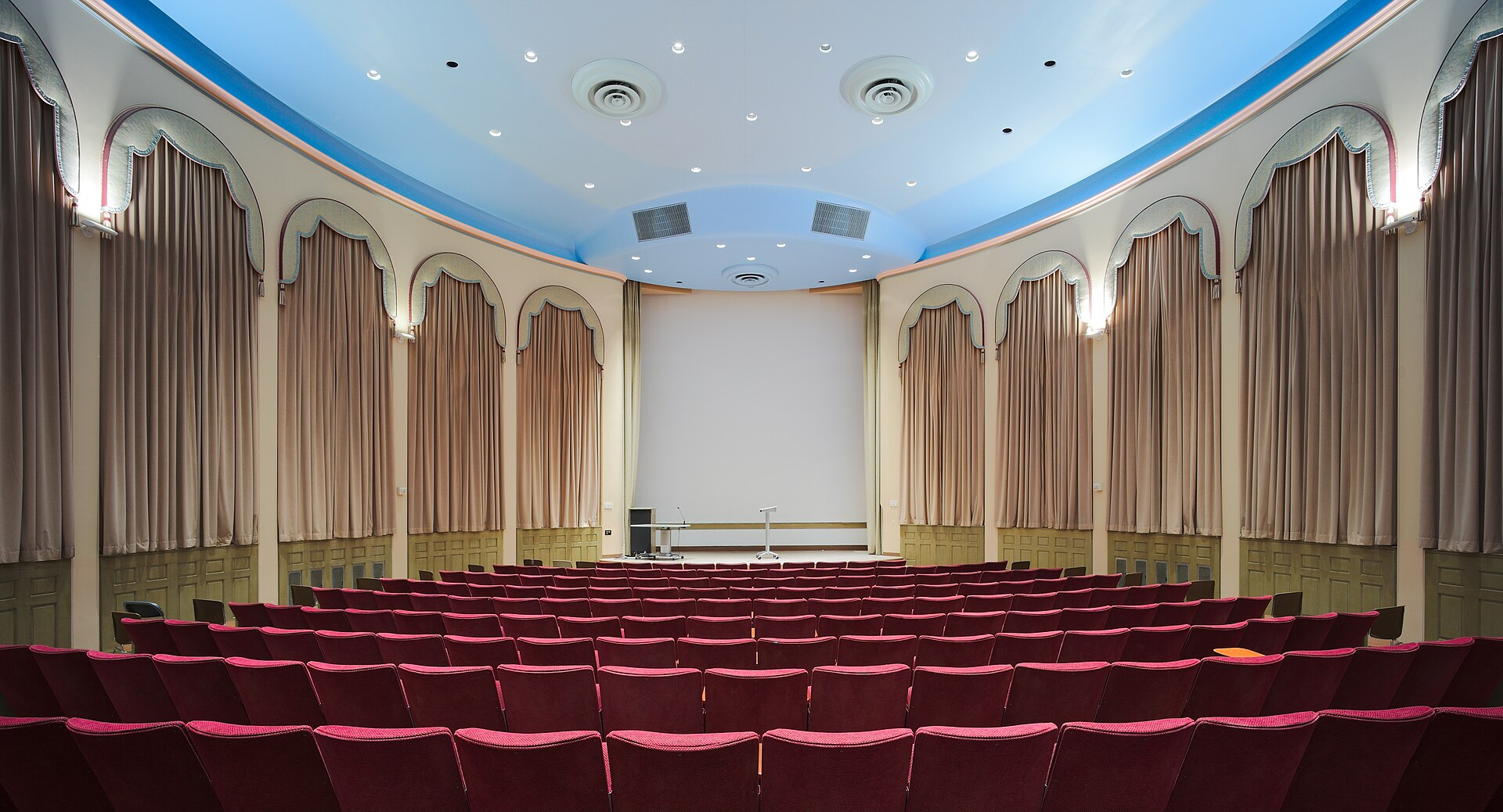 A grand historic cinema auditorium bathed in warm light