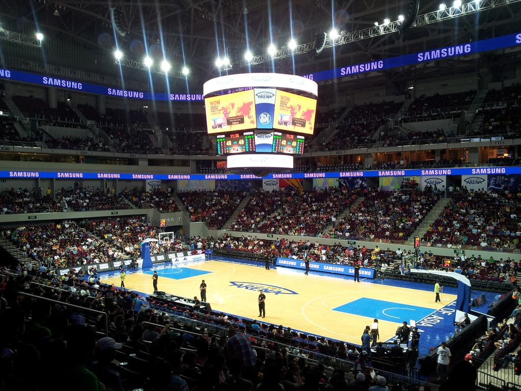 A basketball game in a packed arena under bright lights.