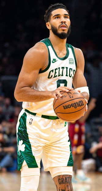 Jayson Tatum in the Boston Celtics home uniform holding a basketball.