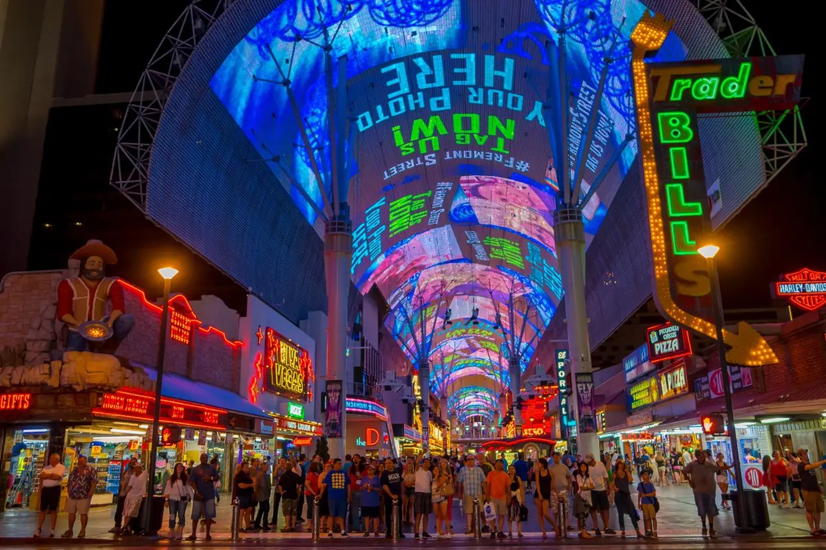 Crowds on Fremont Street under the lit canopy, with the Trader Bill's sign and the D hotel visible