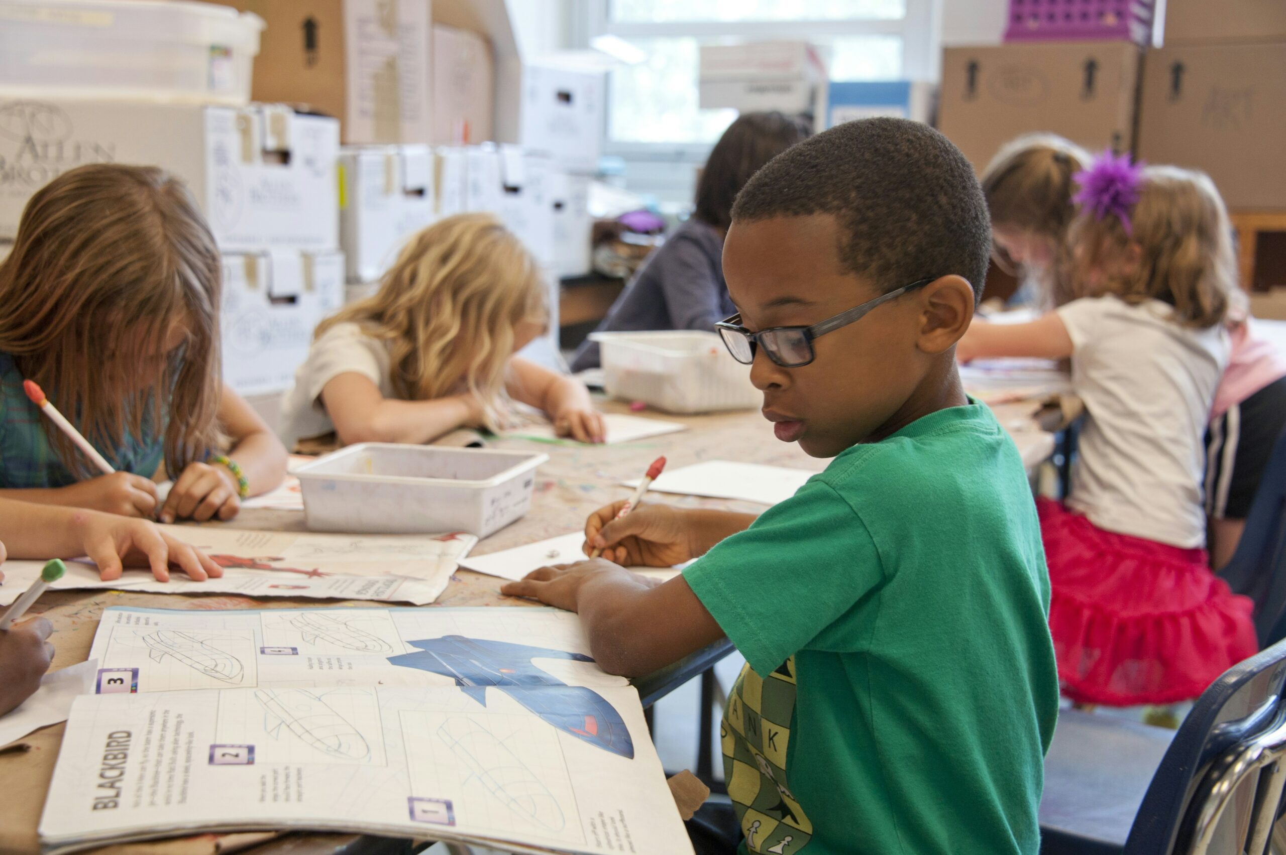 Elementary students working at their desks in a bright classroom