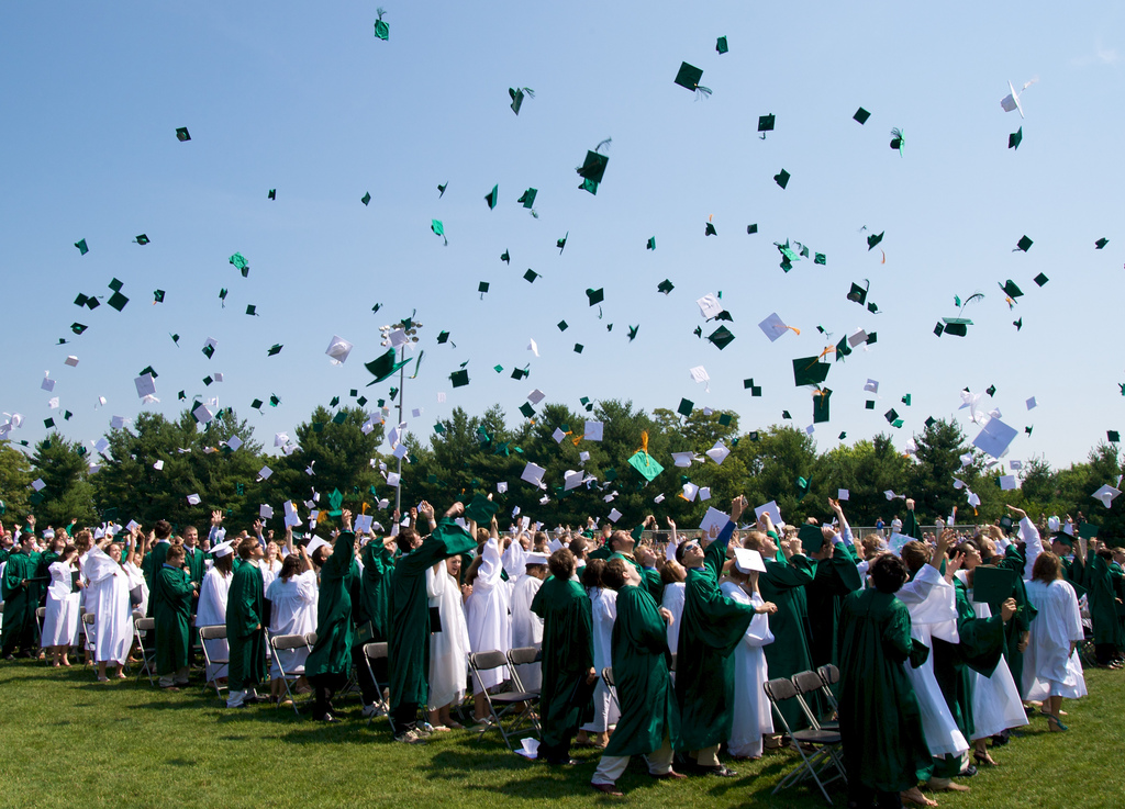 High school graduates tossing their caps into the air