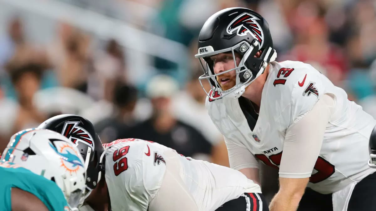 Atlanta Falcons quarterback Cooper Rush (13) takes the snap under center in the white away uniform against the Dolphins.