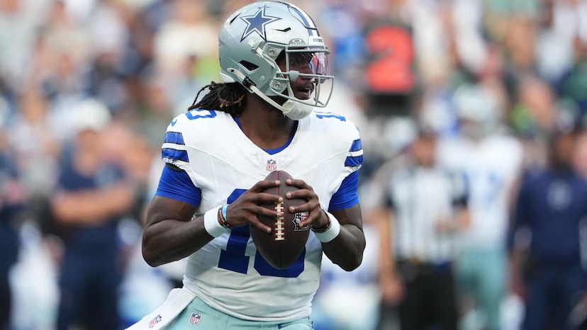 A Dallas Cowboys player in the white road uniform with the navy star helmet