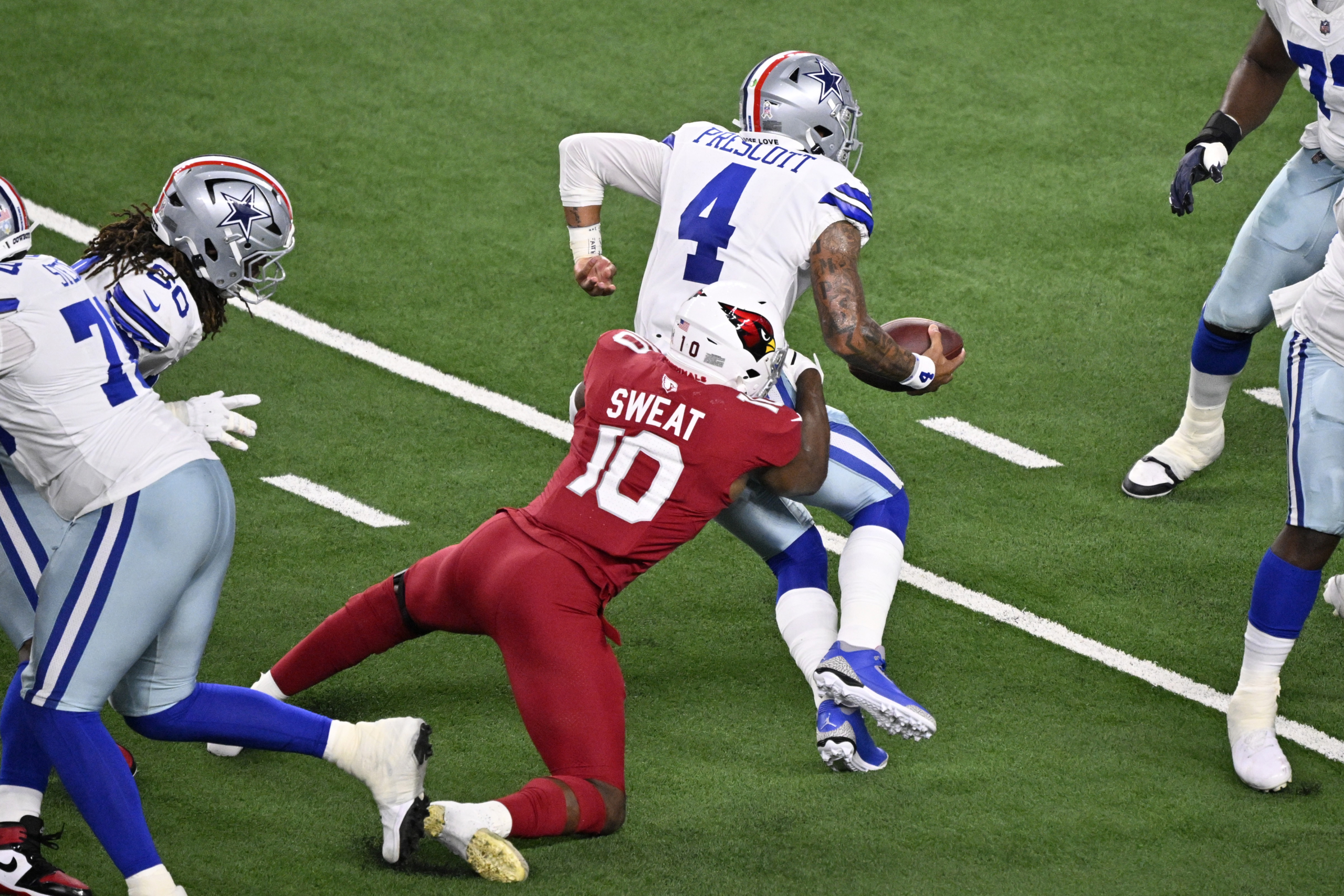 Cardinals edge rusher Josh Sweat sacking Cowboys quarterback Dak Prescott during an NFL game