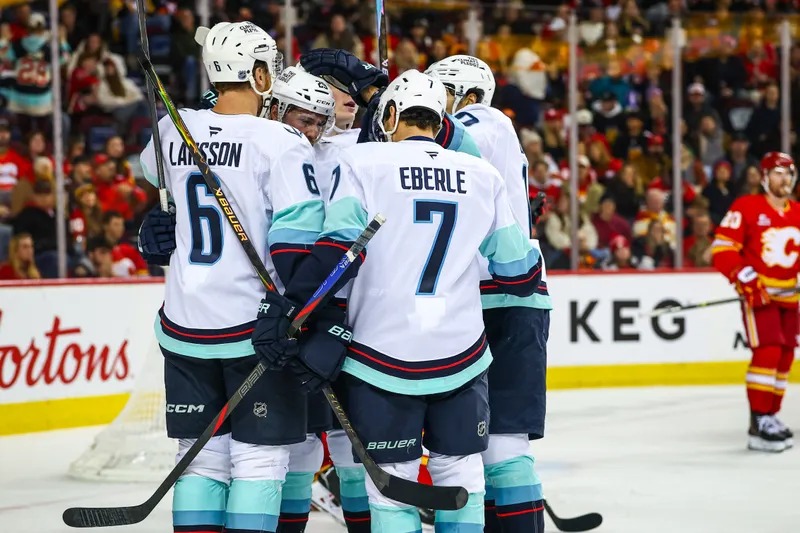 Seattle Kraken players celebrate a goal against the Calgary Flames.