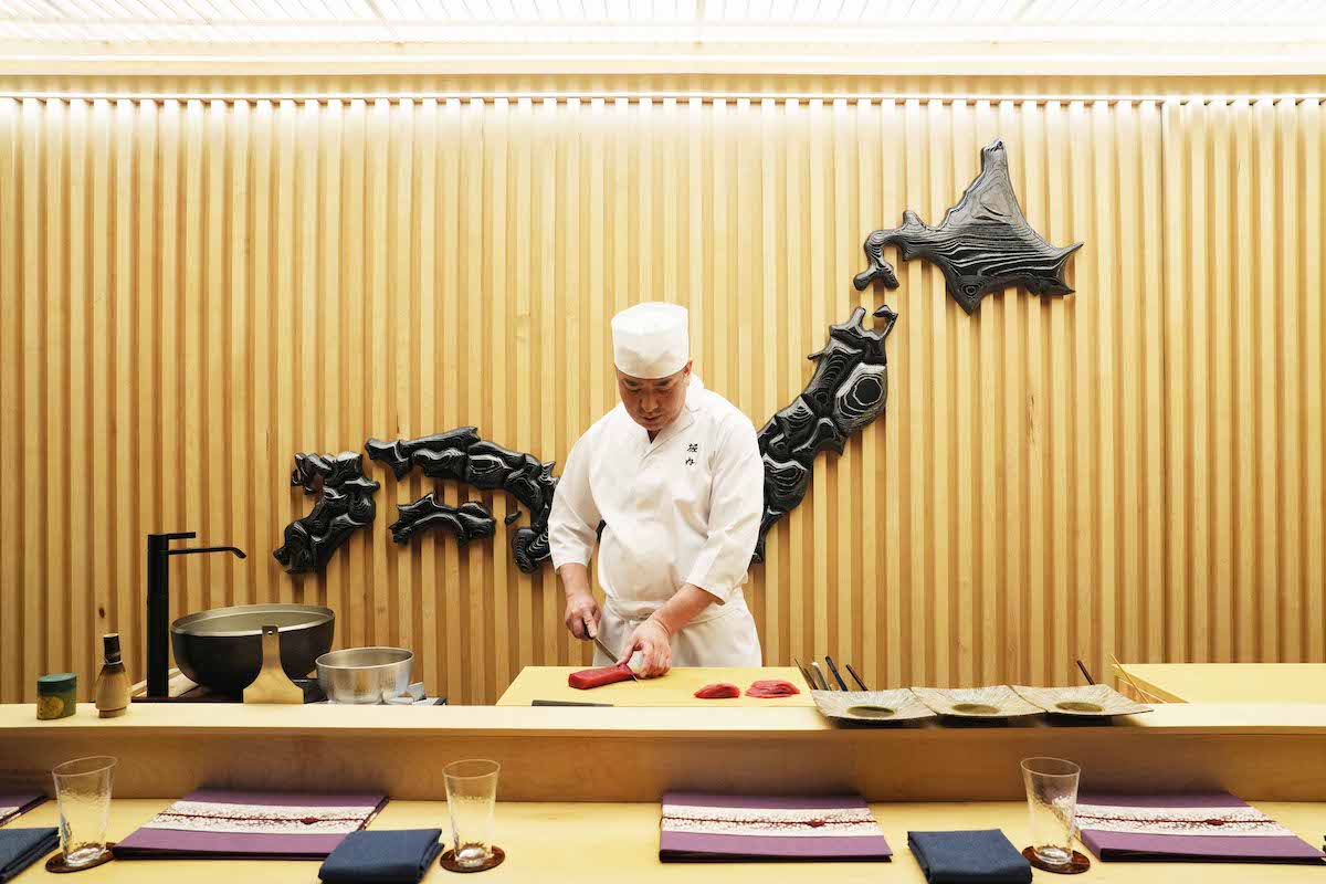 A sushi chef at work in a bright restaurant kitchen