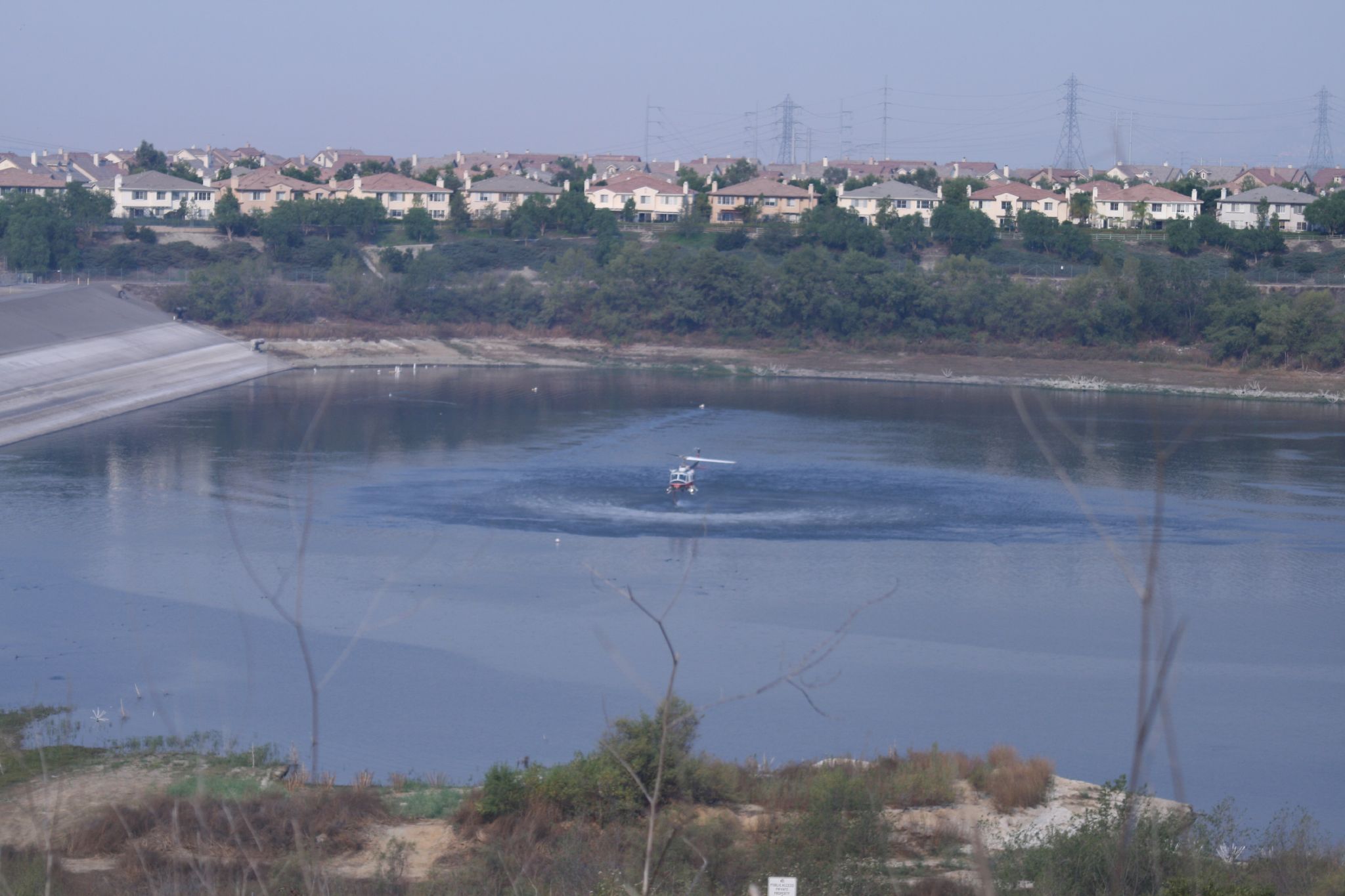 A firefighting helicopter makes a water drop over a brush fire in Orange County (file photo)