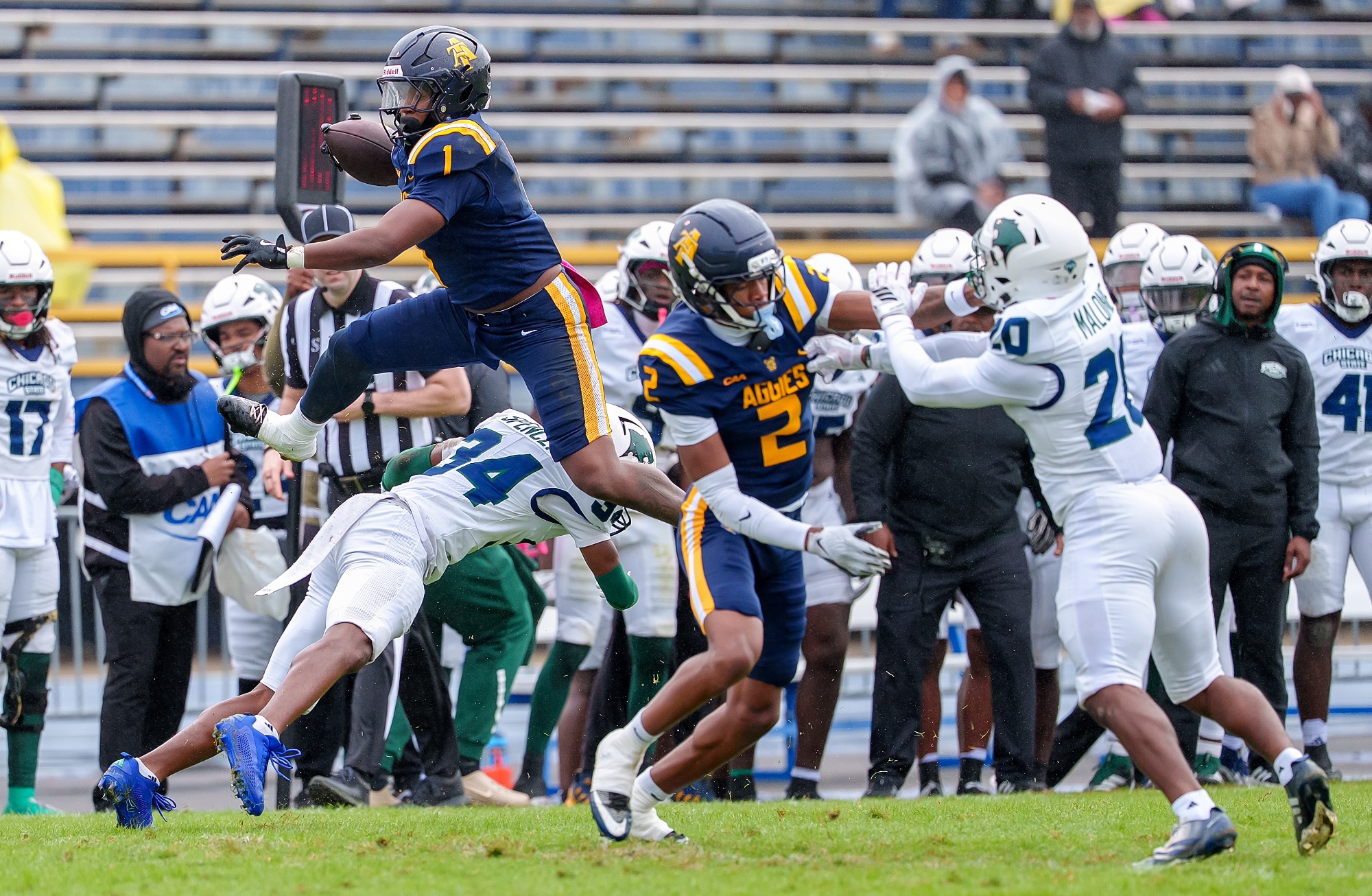 North Carolina A&T ballcarrier J.T. Smith (No. 1) hurdling a Chicago State defender at Truist Stadium, teammate No. 2 blocking beside him