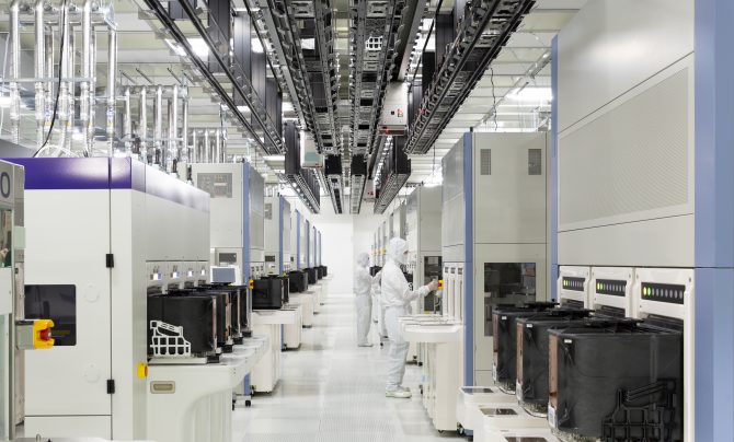 Technicians in bunny suits working inside a chip fab