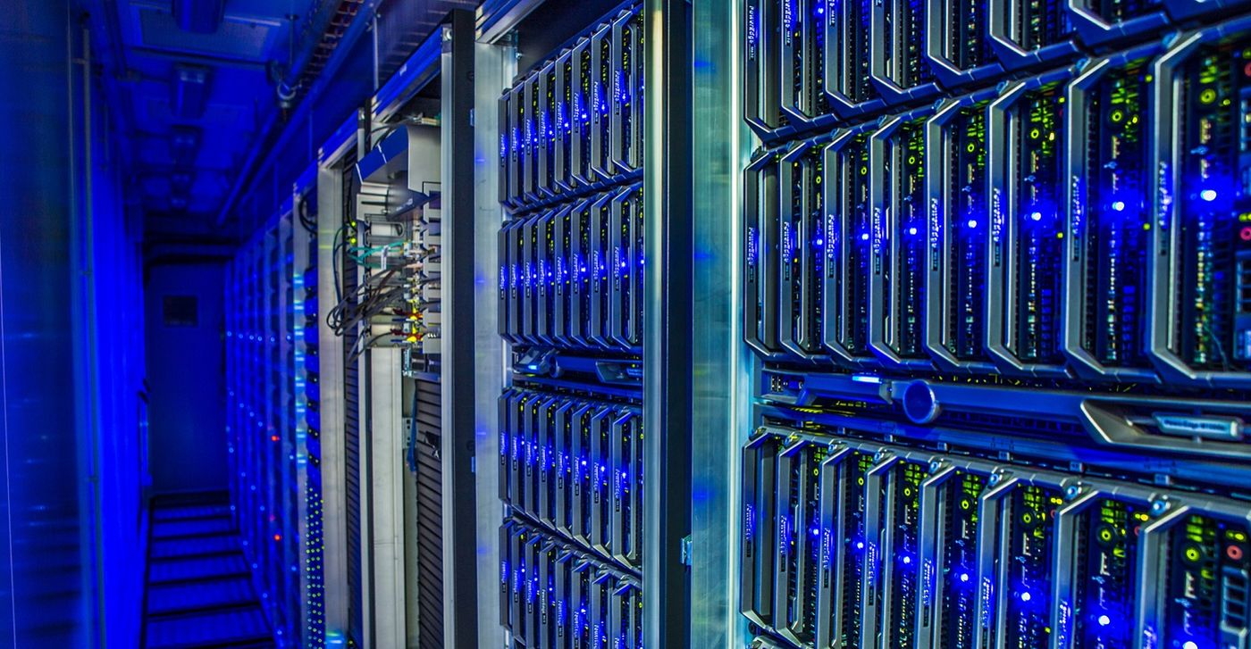 Server racks glowing blue inside a data center.