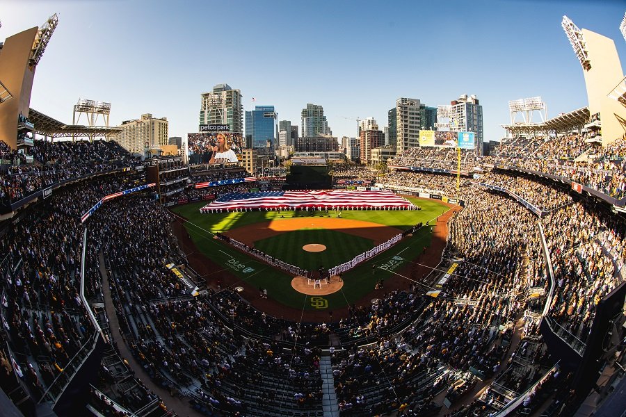 A packed Petco Park with a giant American flag on the field.