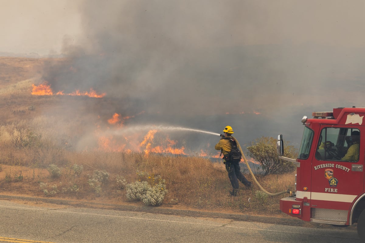 Firefighters responding to a Southern California wildfire with smoke and flames