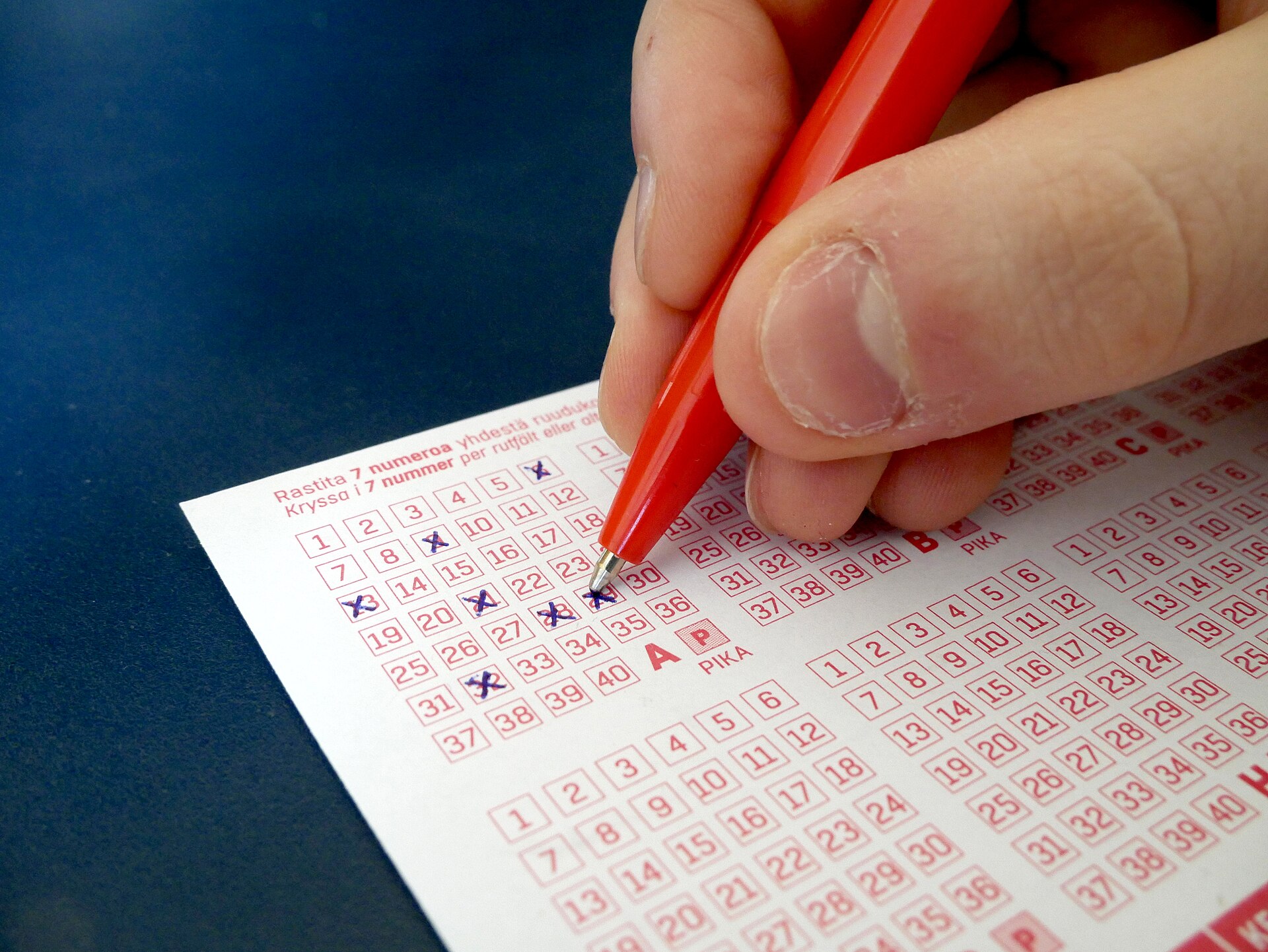 A lottery ticket held up for checking (file photo)